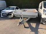 véhicules garés sur un parking avec une remorque attelée à l'arrière