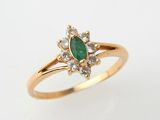 a close up of a gold ring with a green stone