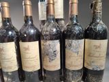 six bottles of wine are lined up in a row on a table
