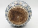 a blue and white vase on a white surface