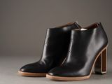 a pair of black leather ankle boots with wooden heel
