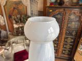 a white vase sitting on a table in a living room
