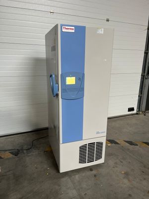 an image of a freezer sitting in a garage next to a garage door