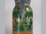 a vase with a painting on it sitting on a table