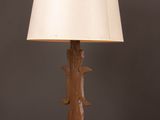 a wooden table lamp with a white shade on top of it