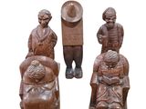 three wooden figurines of people sitting on a bench