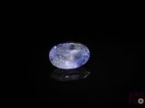 an oval blue sapphire stone on a black surface
