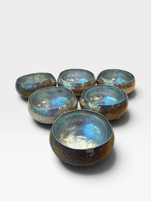 six blue and brown bowls sitting on top of a white surface