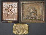 three bronze plaques of a lion and a lion on a black background