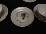 four plates and cups sitting on a black table