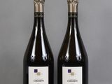 two bottles of wine sitting on top of a table next to each other