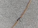 a gold chain with a black bead on top of it