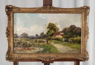 un tableau posé sur un chevalet, avec, en arrière-plan, un tableau représentant une maison