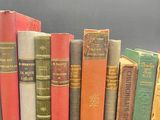 several old books are lined up in a row on a table