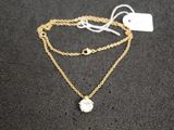 un collier à chaîne en or orné d'une pierre blanche