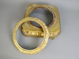 pair of gold bangles on a white surface with a ring in the middle