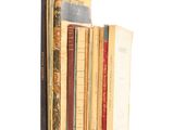 several books are stacked on top of each other on a white surface