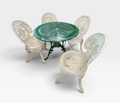 quatre chaises et une table avec un plateau en verre vert