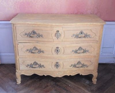 une commode en bois à tiroirs dans une pièce aux murs roses