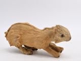 a small toy animal that is running on a white surface