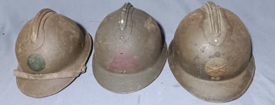 three helmets are lined up on a table with a white table cloth