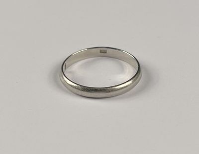 gros plan d'une bague en argent sur une surface blanche