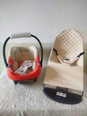 a baby seat and a baby car seat on a bed