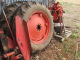 a red tractor that is parked next to a building