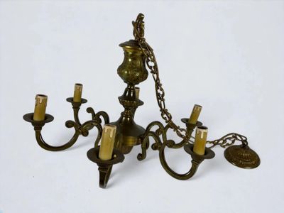 a brass chandelier with five candles on it