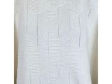 a white sweater with a pattern on the back