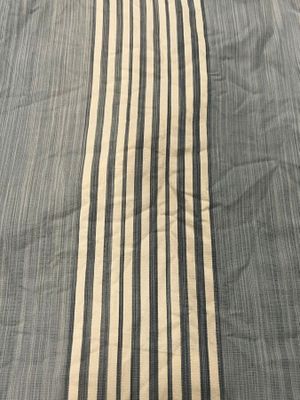 a close up of a bed with a striped comforter on it