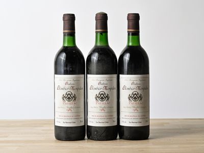 three bottles of wine sitting on top of a wooden table