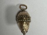 an image of a small gold bell hanging on a white wall