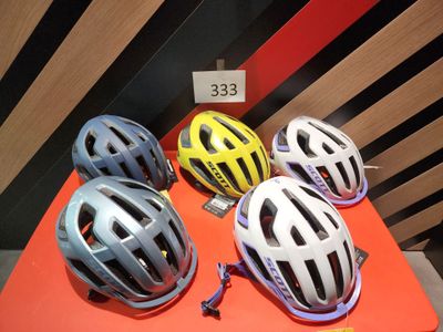 Plusieurs casques sont posés sur une table, accompagnés d'une étiquette de prix.
