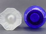 blue and white glass vases with a white flower in the middle