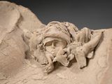 a sculpture of a man with a beard on a rock