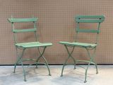 two green chairs sitting next to each other on the floor