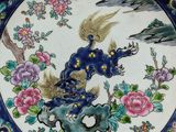 a decorative plate with a bird and flowers on it