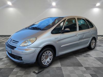 a picture of a small silver car parked in a garage
