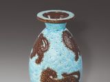a blue and brown vase sitting on a table