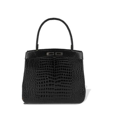 un sac à main en cuir de crocodile noir sur fond blanc