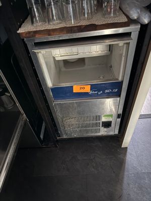 a small refrigerator that has a lot of empty glasses on top of it