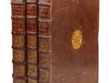 un ensemble de livres anciens composé de trois volumes reliés en cuir marron empilés les uns sur les autres