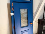 une porte bleue avec une fenêtre au milieu d'une pièce