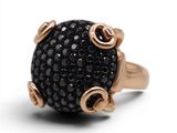 une image représentant une bague noire et dorée ornée de pierres noires