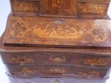 a wooden desk with drawers and a clock on top of it