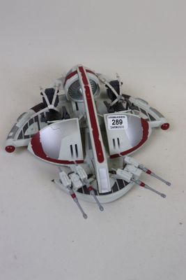 une petite maquette de vaisseau spatial posée sur une surface blanche