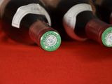 several bottles of wine are lined up on a red cloth
