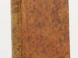 un vieux livre posé sur une surface blanche