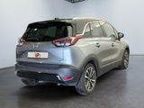the back of a silver car in a showroom with white walls